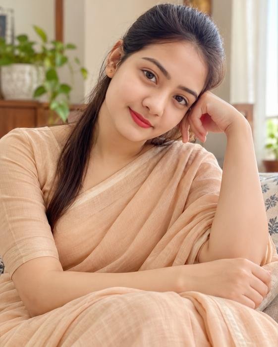 Indian woman in plain saree with minimal jewelry at home