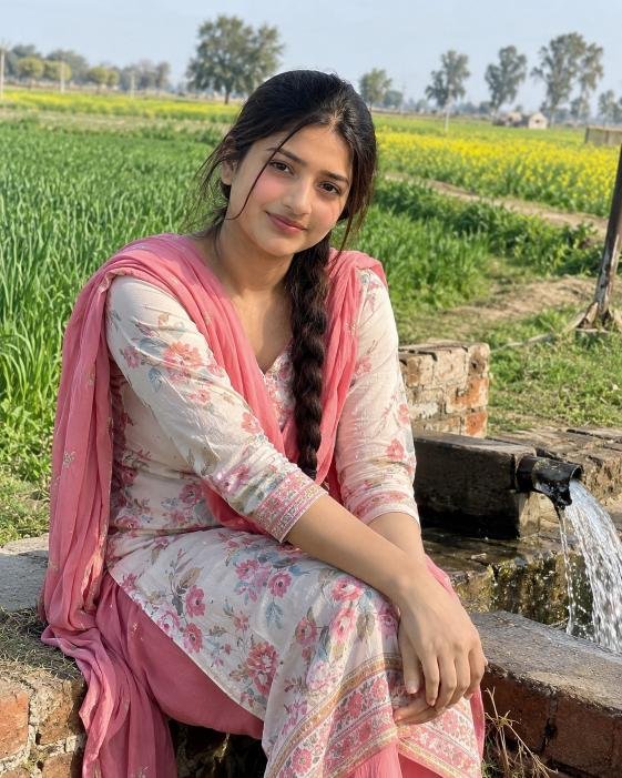 Simple gaon ki ladki in traditional suit near farmland