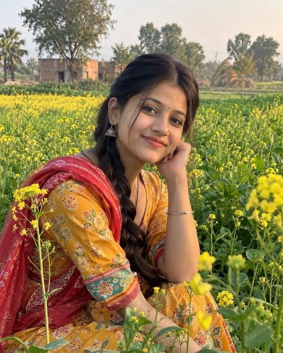 Young Indian village girl posing near mustard fields