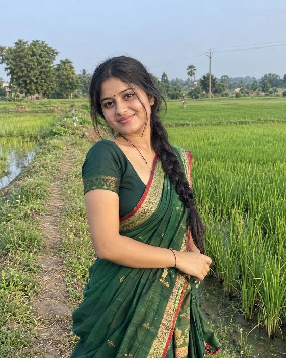 Young rural woman surrounded by green village fields