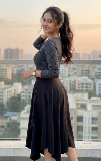 Young woman in simple black dress standing on balcony